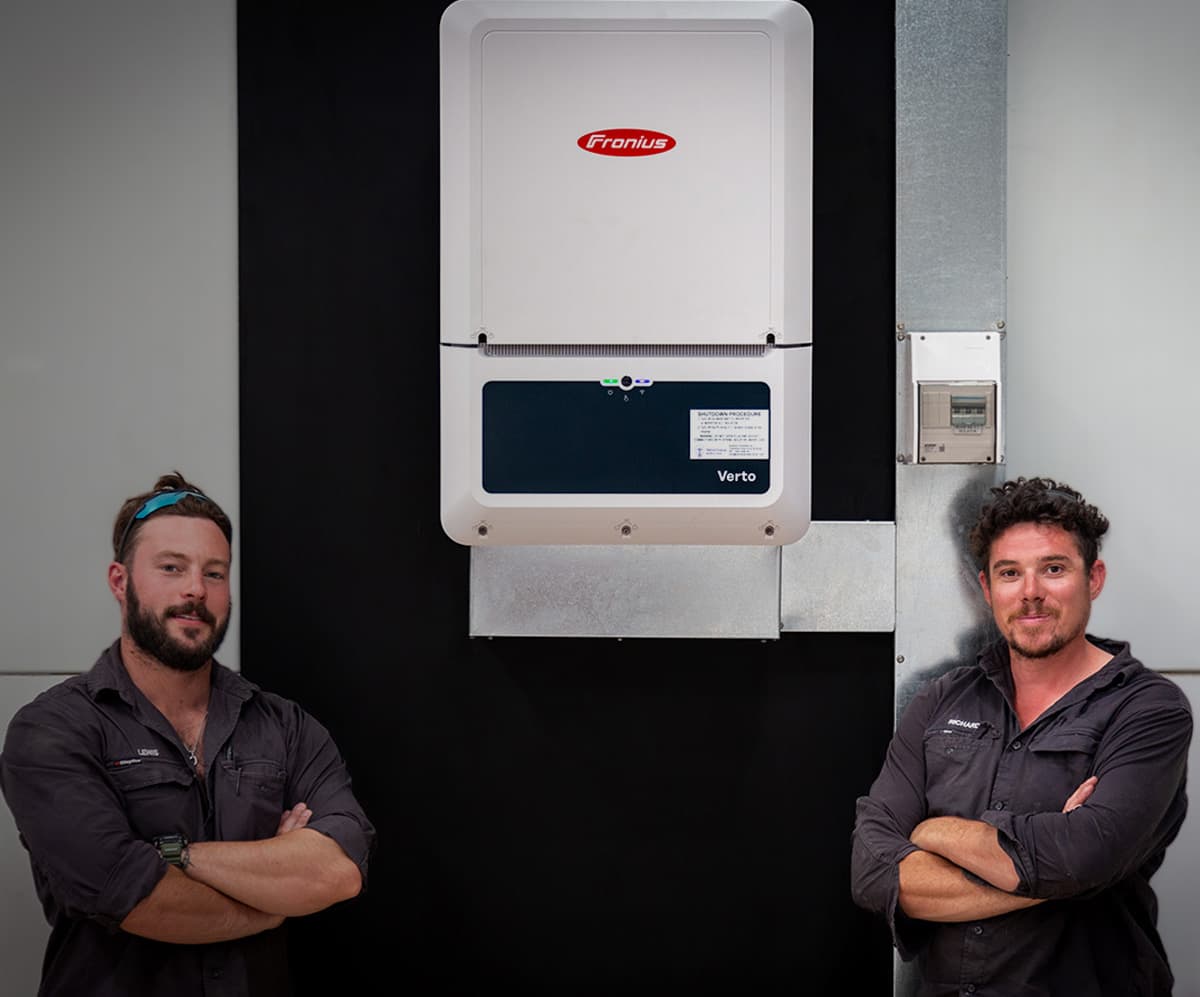 Two Central Solar electricians at an installed inverter